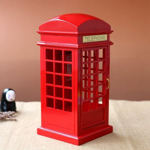 Red telephone booth model on a beige surface with a plain background